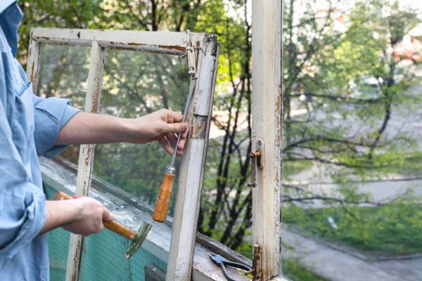 Man som renoverar ett gammalt fönster.